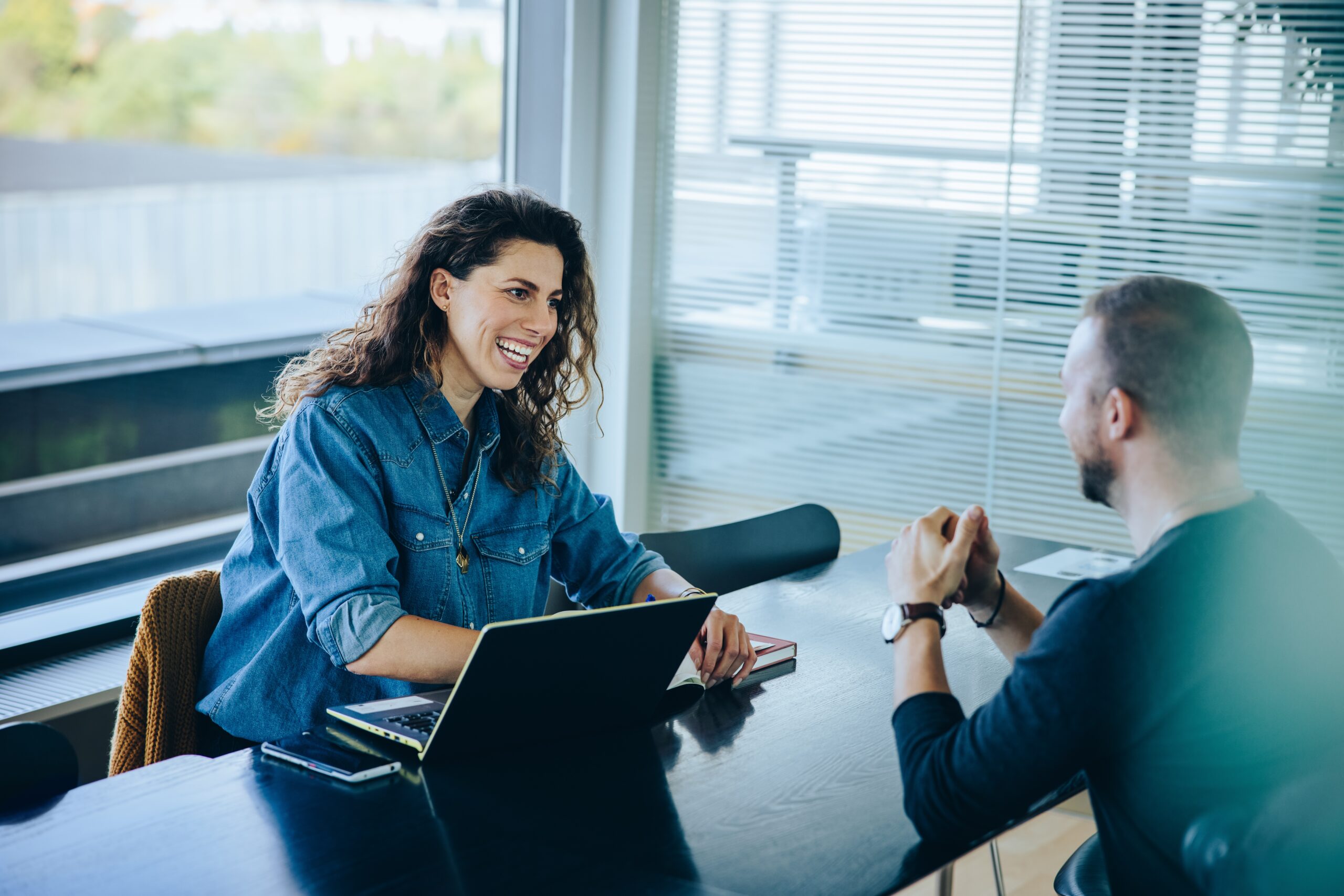 Man and woman sitting at a table having an interview.